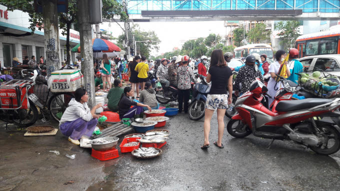 Tiểu thương chợ Hưng Dũng phải tràn ra mặt đường để buôn bán sau khi chợ bị "nhấn chìm".
