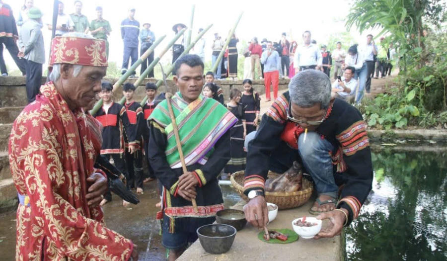 Bà con buôn Hra Ea Tlă theo chân thầy cúng mang lễ vật đến bến nước để thực hiện nghi lễ. Ảnh: Báo Đắk Lắk