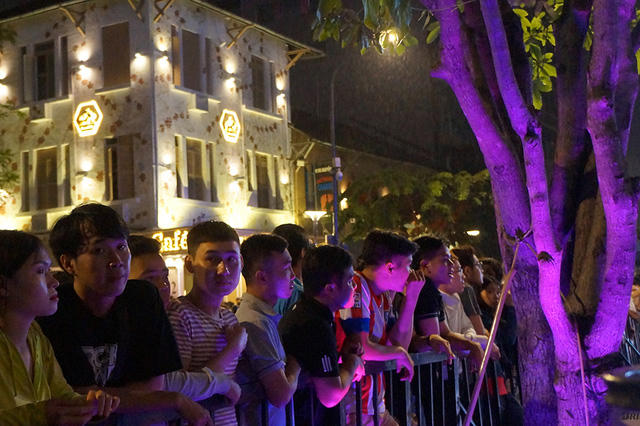 Phía ngoài hàng rào của khu vực biểu diễn, các khán giả vẫn tiếp tục hướng mắt về sân khấu để theo dõi chương trình.