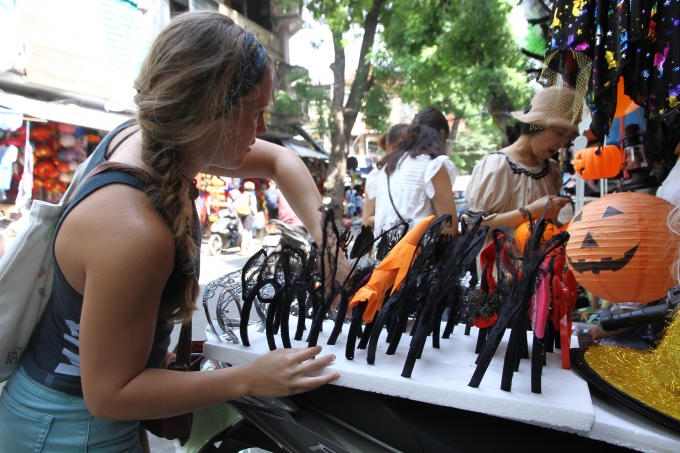 Một du khách nước ngoài đang say sưa chọn lựa một món đồ đẹp nhất.