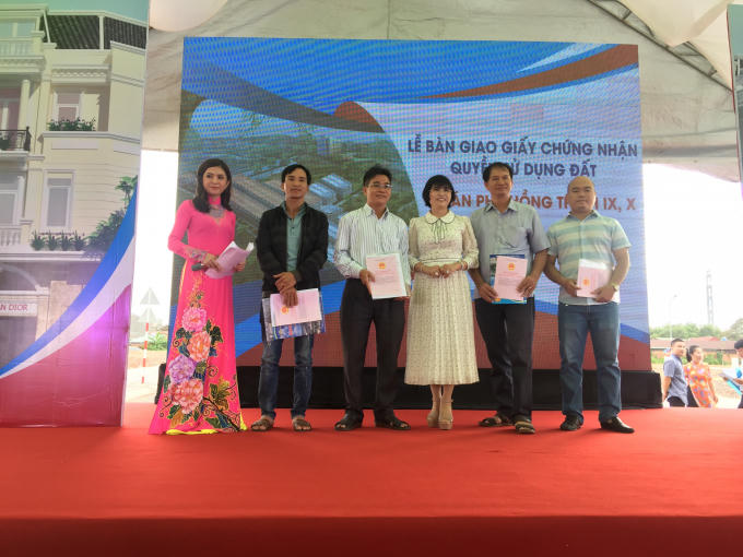 Bà Phạm Thị Hường (váy trắng, ở giữa), Chủ tịch HĐQT Công ty BĐS Phú Hồng Thịnh trao sổ hồng cho khách hàng. Trong buổi lễ, hầu hết các tân chủ nhân thuộc dự án Phú Hồng Thịnh IX và X đều vui mừng trước tiến độ trao sổ hồng của chủ đầu tư vượt hơn kỳ vọng của khách hàng.