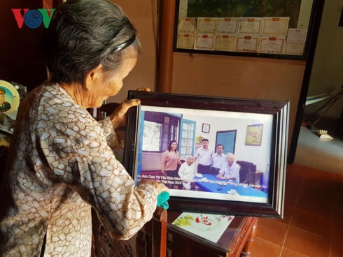 Bà Võ Thị Minh đem bức ảnh nguyên Chủ tịch nước chụp với gia đình ra lau chùi.