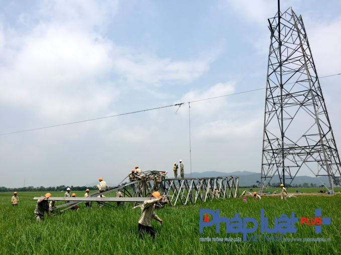 Công nhân đang dọn dẹp phần đổ nát của cột điện.