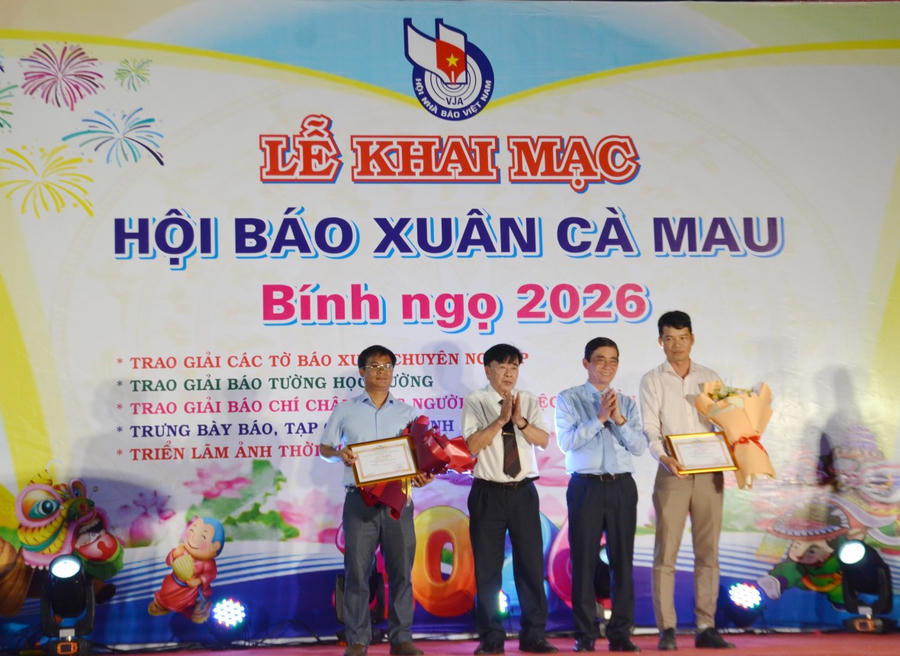 Nhà báo Nguyễn Duy Hoàng – Phó Chủ tịch Hội Nhà báo tỉnh (bên trái) cùng ông Nguyễn Hoàng Dự – Phó Giám đốc Sở Giáo dục và Đào tạo, trao thưởng và tặng hoa cho các đơn vị đạt giải A - Báo tường học đường.