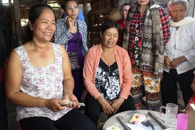 Bà Hường (trái) bán vé số cạnh cây chuối "khủng" của mình.