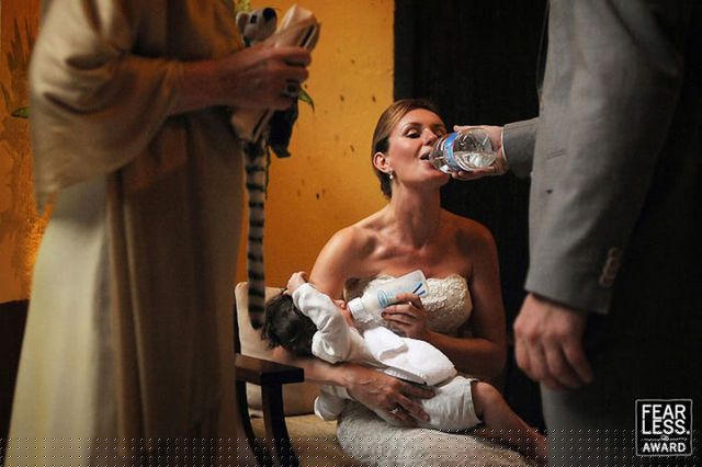 Cô dâu trong bức ảnh đang vừa mỉm cười vừa uống nước trong khi cho con bú bình sữa. Bức ảnh tuyệt đẹp này là tác phẩm của Daniel Aguilar gửi dự thi trong giải thưởng Fearless năm 2011.