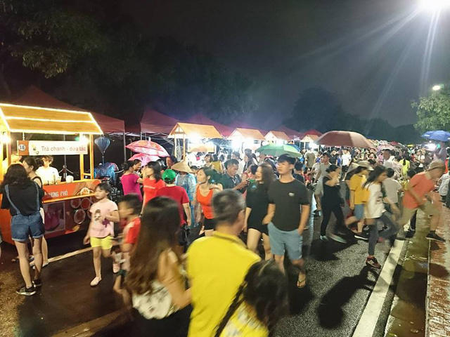 Cảnh người dân đội mưa tham dự khai trương phố đi bộ Trịnh Công Sơn tối 11/5.