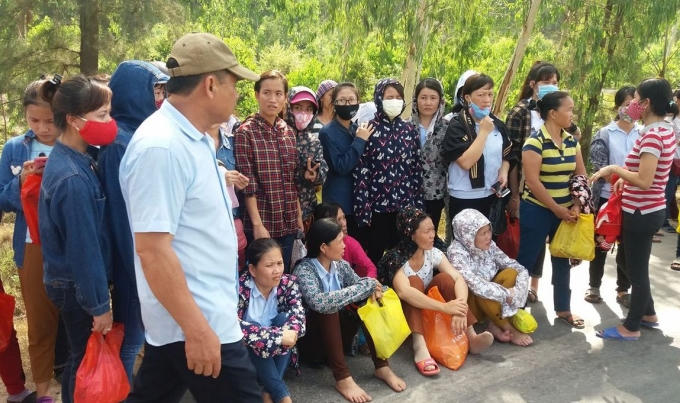 Những công nhân mệt mỏi ngồi bên vệ đường.