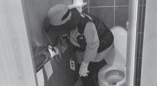 Lực lượng chuyên trách dò camera nhìn trộm trong một phòng vệ sinh công cộng.