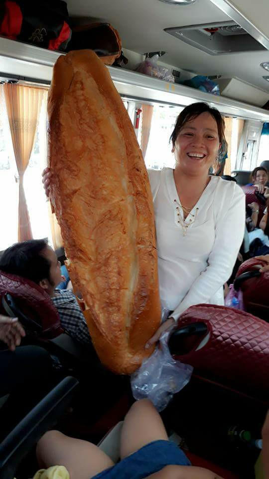 Mọi người hào hứng khoe chiếc bánh mì khổng lồ mà mình mới mua được.