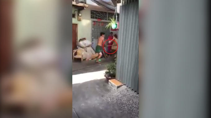 Hình ảnh người đàn ông cầm chổi vụt vào người mẹ già.