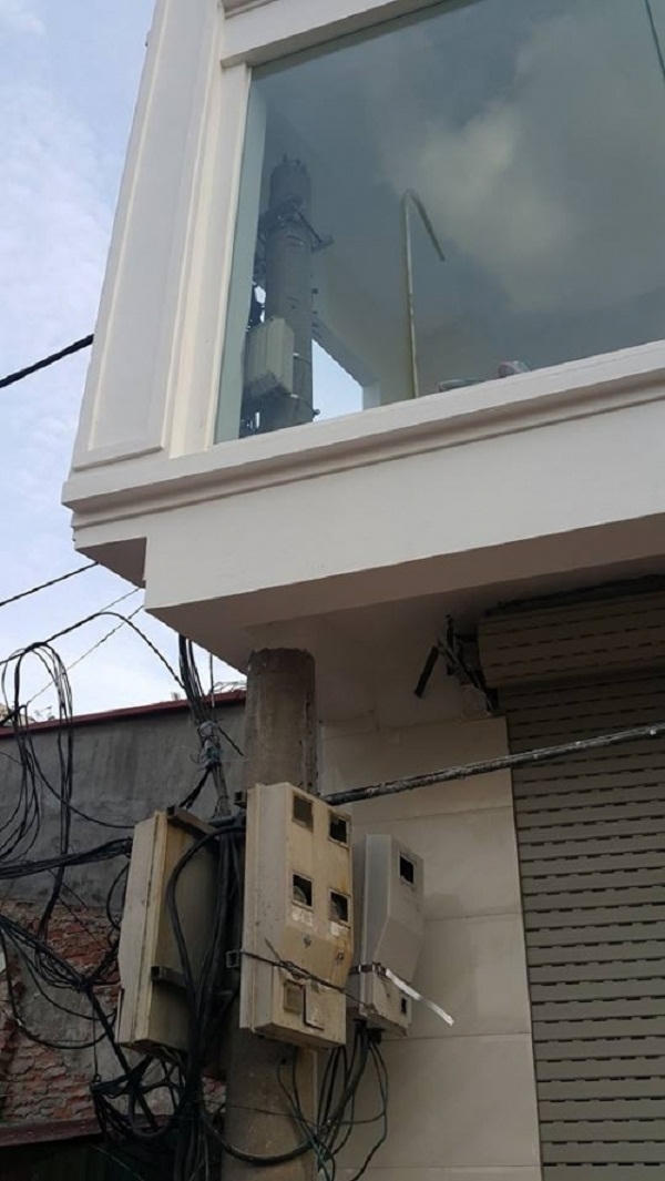 Phần đầu của cột điện nằm trong tầng 2 của ngôi nhà. Ảnh: Nhất Nam.