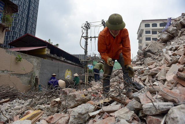 Công nhân đang gom sắt vụn tại công trường.