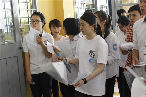 Trước khi thí sinh vào phòng thi, các cán bộ coi thi sẽ nhắc nhở những vật dụng không được phép mang vào. Ảnh ĐH.