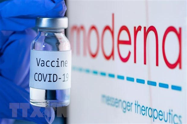 Vaccine ngừa COVID-19 bên biểu tượng của Hãng dược phẩm Moderna. (Ảnh: AFP/TTXVN)