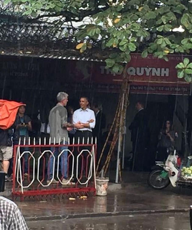 Tổng thống Obama đứng trú mưa trong quán trà đá.