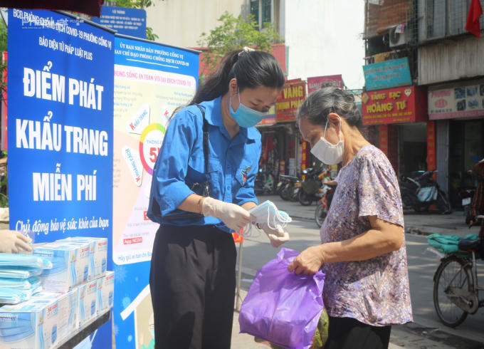 Người dân nhận khẩu trang trước khi đi vào chợ.