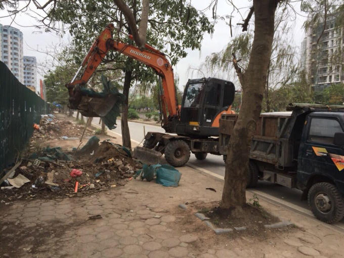 Lực lượng chức năng huy động xe cẩu dọn dẹp phế thải do người dân đổ trộm dọc bờ sông Lừ.