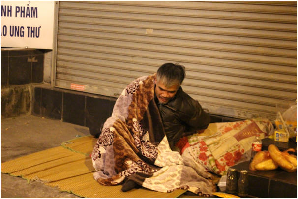 Đã mấy năm nay, người đàn ông này ngủ ngay tại ven đường Hai Bà Trưng. Tấm chăn mỏng không xua nổi cái lạnh hằng đêm.