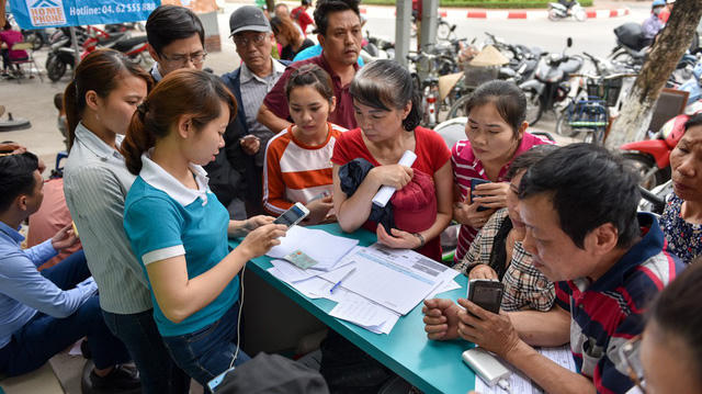 Do người dân đến làm thủ tục quá đông, điểm giao dịch phải kê bàn ra ngoài vỉa hè để kịp phục vụ khách hàng.
