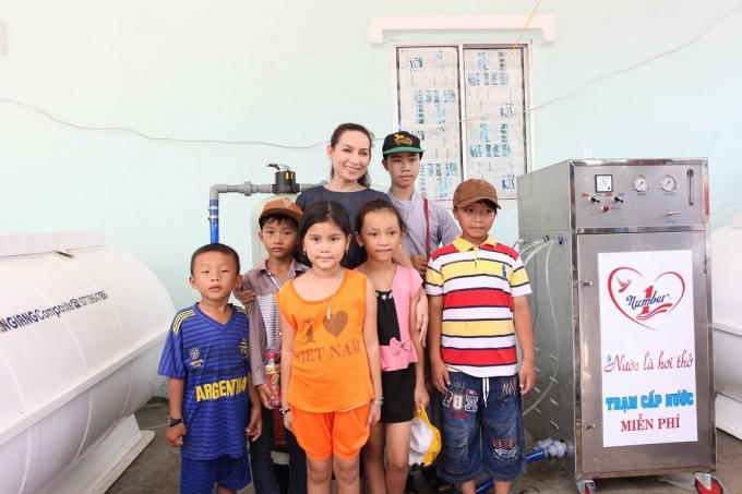Ca sĩ Phi Nhung chụp ảnh lưu niệm cùng trẻ em địa phương trong hành trình trao máy lọc nước mặn thành nước ngọt cho người dân đồng bằng sông Cửu Long.
