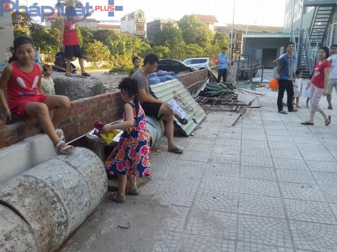 Quang cảnh lộn xộn, nhếc nhác, sân chơi được sử dụng để tập kết vật liệu xây dựng.