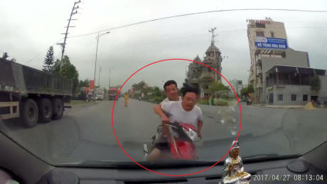 Hình ảnh 2 người đàn ông đối đầu với ô tô.