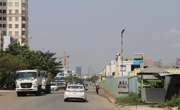 Trong khi dự án lấn chiếm vỉa hè thì bên dưới lòng đường, xe tải và xe ben chở vật liệu thường xuyên ra vào công trường.