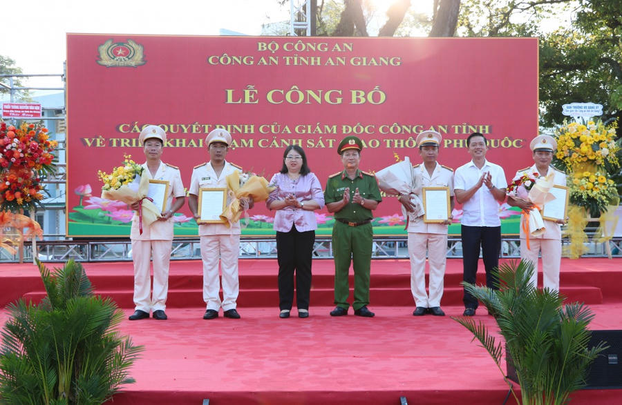 Đồng chí Đại tá Diệp Văn Thế, Phó Giám đốc Công an tỉnh An Giang; đồng chí Đặng Thị Hồng Gấm, Phó Bí thư Thường trực, Chủ tịch HĐND đặc khu Phú Quốc và đồng chí Trần Minh Khoa, Chủ tịch UBND đặc khu Phú Quốc tặng hoa chúc mừng Ban Chỉ huy Trạm Cảnh sát giao thông Phú Quốc