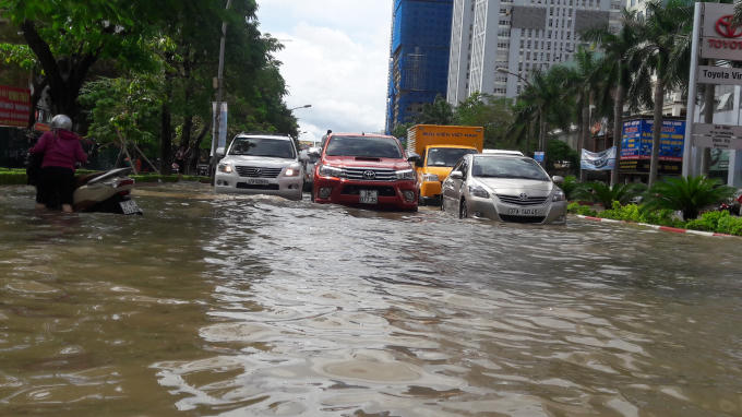 Từng đoàn phương tiện bì bõm "bơi" trên các tuyến phố chính ở TP Vinh bị ngập sâu trong nước.
