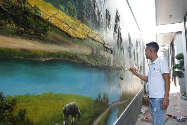 Anh Lê Quang Bài đang hoàn thiện bức tranh đồng quê cho một công trình. 