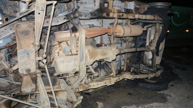 Chiếc xe lật nghiêng cháy đen.