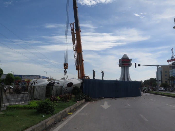 Chiếc container lật nghiêng giữa đường khiến giao thông bị ùn tắc cục bộ.