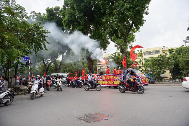 Các cổ động viên máu lửa khởi đầu bằng màn diễu hành với những bộ đồng phục cờ đỏ sao vàng rực rỡ quanh các trục đường. (Ảnh: Dân trí)
