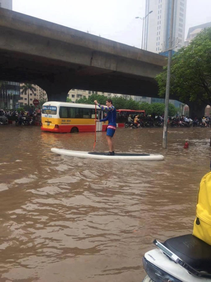 Bỏ xe theo thuyền! Trong khi các phương tiện khác đang phải chịu cảnh ngập úng và ùn tắc thì một anh "Tây" đang thảnh thơi bơi thuyền trên đường Nguyễn Hoàng, Hà Nội.