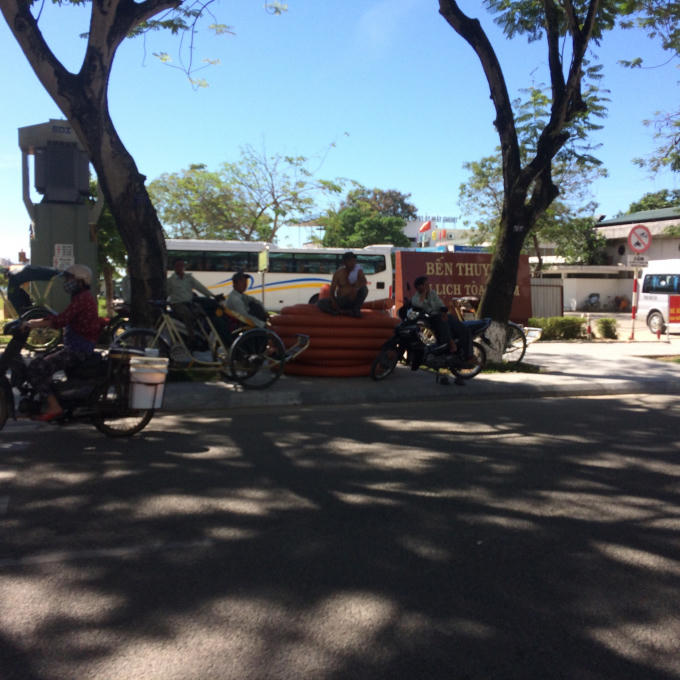 Các bác xe ôm tranh thủ nghỉ trưa dưới bóng dâm khi không có khách.