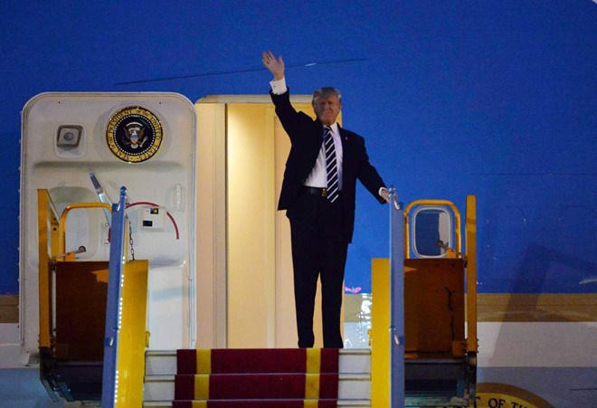 Tổng thống Trump đứng trên cửa chuyên cơ Air Force One ở sân bay Nội Bài vẫy chào mọi người. Ảnh: Zing.