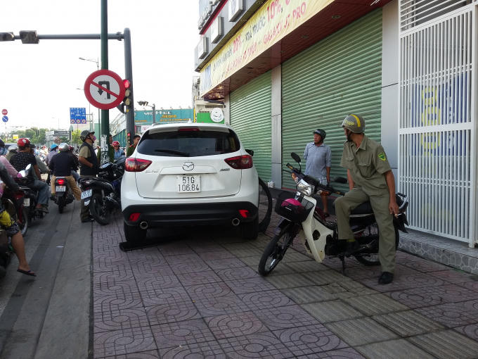 Chiếc ô tô Mazda 5 leo lên vỉa hè khi bị người dân truy đuổi.