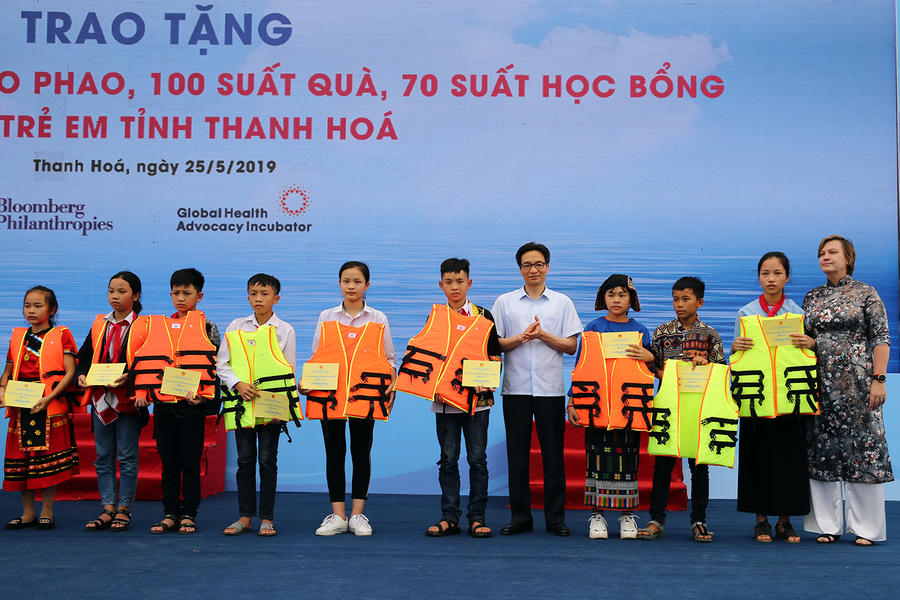 Phó Thủ tướng Vũ Đức Đam trao tặng áo phao cho các em học sinh. Ảnh: VGP/Đình Nam