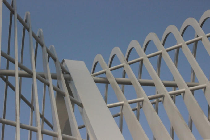 Các thanh sắt lơn nhỏ, với các hình dạng khác nhau đan xen tạo thành mái của cổng chào.