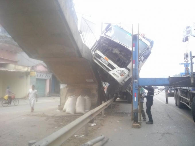 Chiếc xe tải treo chênh vênh trên cầu dành cho người đi bộ. (Ảnh: Phùng Nguyện).