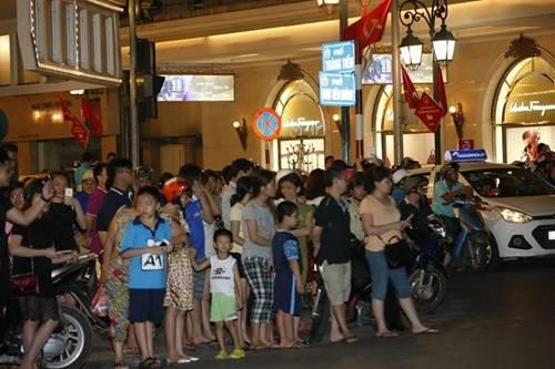 Người dân đứng 2 bên chào đón đoàn xe. (Ảnh: Tiền Phong)