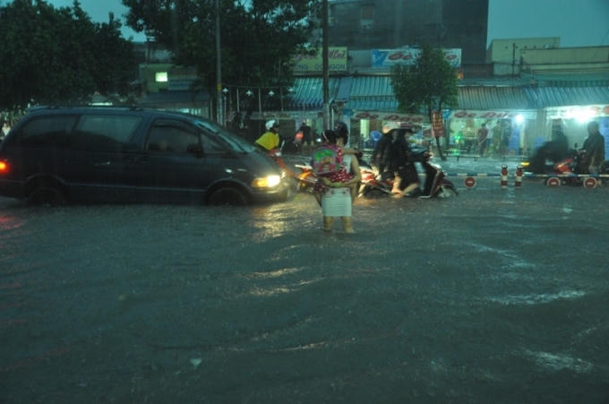 Người phụ nữ bồng con gái đang chơi vơi giữa dòng nước mỗi lúc càng ngập sâu hơn.