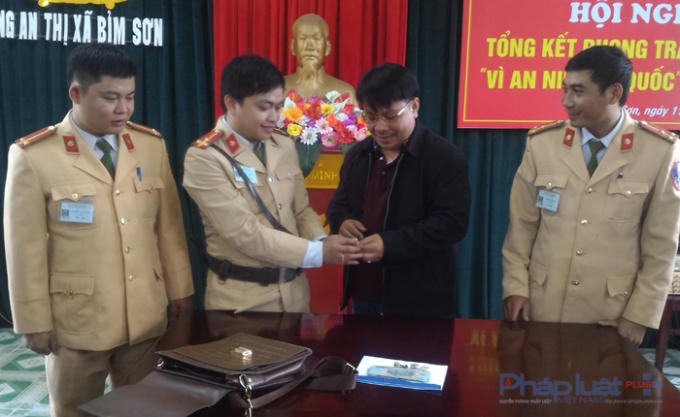 Thượng úy Đỗ Đức Dũng, người trực tiếp nhặt được túi đồ đang cùng chủ nhân kiểm kê lại tài sản. (Ảnh: A.Thắng)