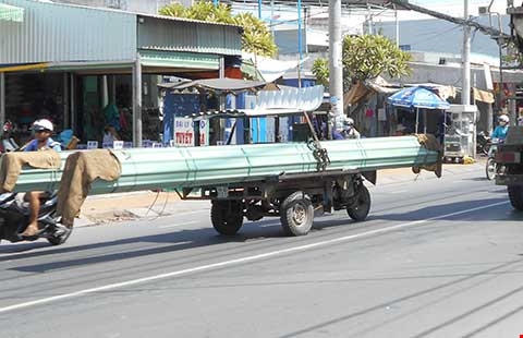 Những chiếc xe máy chở tôn như này chiếm hết diện tích đường phố.