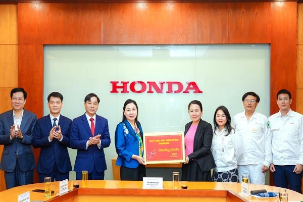 Bà Đinh Thị Lụa, Phó Bí thư Thường trực Tỉnh ủy và Đoàn công tác trao quà cho đại diện lãnh đạo Công ty Honda Việt Nam, KCN Đồng Văn II.