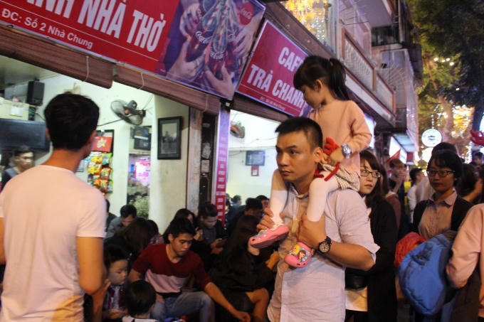 Đường phố đông ngịt khiến nhiều em nhỏ phải nhờ đến sự "trợ giúp" của bố mẹ mới có thể chen qua.