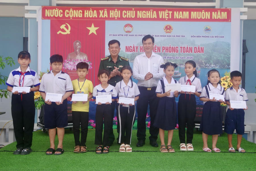 Đại tá Võ Văn Dúl - Trưởng phòng Nghiệp vụ Ban Chỉ huy BĐBP tỉnh Cà Mau và ông Nguyễn Văn Chờ - Chủ tịch UBND xã Phú Tân, trao học bổng Võ Văn Kiệt cho học sinh có hoàn cảnh khó khăn.