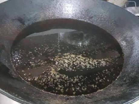 Dầu bị chiên đi chiên lại nhiều lần đã chuyển màu đen. Ảnh: Phụ huynh cung cấp.