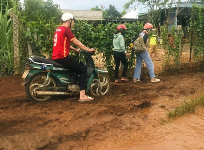 Nhiều người dân phải đi theo ven bờ đất cao bên đường để tránh ngập nước.
